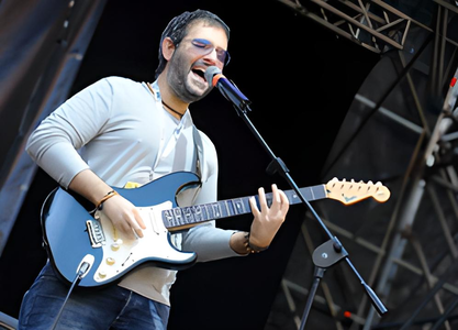 Dario Sgrò canta e suona la chitarra elettrica sul palco.