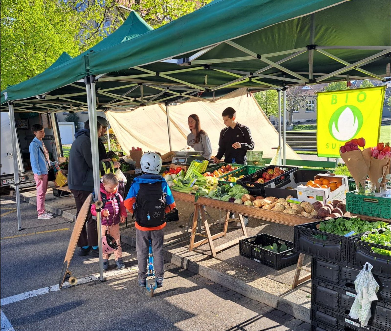 Martin Hengartner vende i prodotti biologici della sua azienda agricola al mercato settimanale, con l’aiuto di alcuni alunni della regione. (Foto: Martin Hengartner)