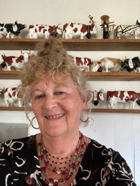 Foto di Marie Henchoz davanti a una cornice con figure di mucche.